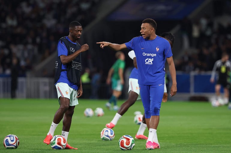 El delantero de Francia Kylian Mbappé (der.) y el delantero de Francia Ousmane Dembélé calientan antes del partido amistoso internacional de fútbol entre Francia e Irlanda del Norte en el estadio Decathlon Arena.