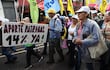 Personas sostienen carteles y banderas durante una manifestación este martes, en Asunción (Paraguay).