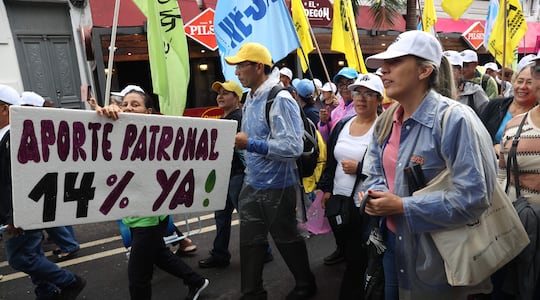 Personas sostienen carteles y banderas durante una manifestación este martes, en Asunción (Paraguay).