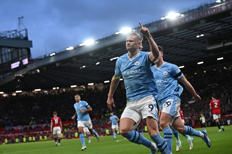 El delantero noruego del Manchester City # 09 Erling Haaland (C) celebra después de marcar el gol inicial desde el punto de penalti durante el partido de fútbol de la Premier League inglesa entre Manchester United y Manchester City en Old Trafford en Manchester, noroeste de Inglaterra, el 29 de octubre de 2023.