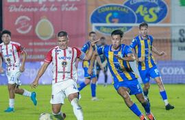 El volante y capitán del Sportivo Carapeguá, Eric Ramos conserva la posesión del esférico ante la marca del atacante "conquistador", César Alonso. Foto: @CopaParaguayAPF
