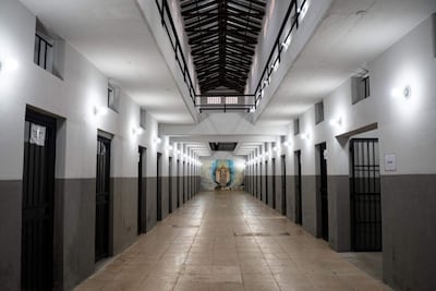 Pasillo amplio del Centro Nacional de Prevenidos en Asunción, con paredes blancas y una pintura mural religiosa al fondo.