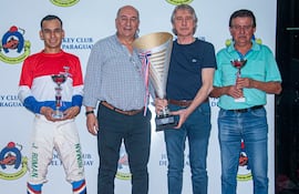 El jockey Juan Román, los propietarios de Amaranto Víctor Florentín y Víctor Ivo Ubaldi, y el entrenador Francisco Rotela, con sus trofeos en el "Fundación de Asunción".