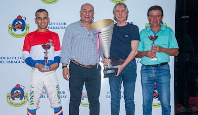 El jockey Juan Román, los propietarios de Amaranto Víctor Florentín y Víctor Ivo Ubaldi, y el entrenador Francisco Rotela, con sus trofeos en el "Fundación de Asunción".