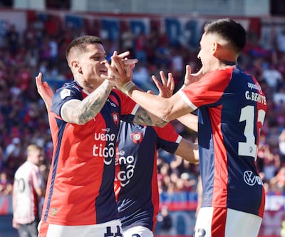 Futbolistas de Cerro Porteño celebrando, con camisetas rojas y azules, gestos de alegría y una multitud animada de fondo.