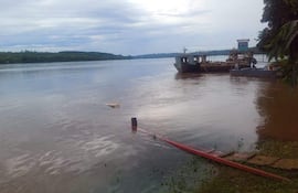 Ambiente acuático en Itapúa, con barcos en el río y vegetación inundada por el agua tranquila bajo un cielo nublado.