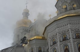 Bomberos combaten un incendio en la catedral de la Dormición, en Kiev, luego de un bombardeo ruso contra la capital ucraniana.