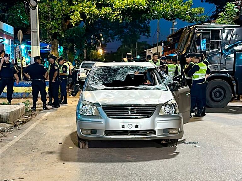 Efectivos de la Policía observan el auto de uno de sus camaradas, que fue completamente destrozado por miembros de la barra brava de Luque.