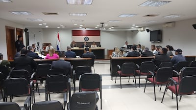 Mikhaela Rolón Melgarejo en audiencia, vestida formalmente, leyendo carta a jueces mientras varios asistentes la observan con expresiones diversas.