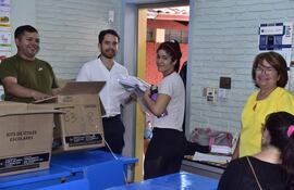 Una mamá recibe el kit escolar de la mano del director de la escuela básica Delfín Chamorro, del barrio Roberto L. Petit de Asunción.