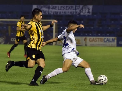Daniel Pérez (i), futbolista de Guaraní, pelea por el balón en un partido frente a Sportivo Ameliano por el fútbol paraguayo en el estadio Luis Alfonso Giagni, en Villa Elisa, Paraguay.