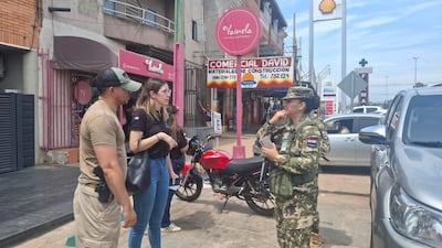 Andrea Ríos con uniforme militar y policías, en una conversación en una calle comercial de Mariano Roque Alonso.