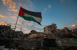 Una bandera palestina cerca de edificios destruidos en la Ciudad de Gaza.