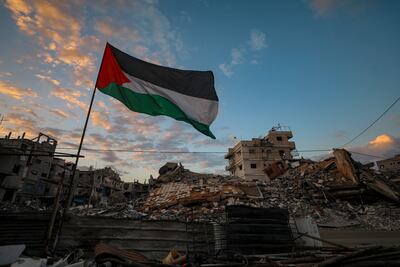 Una bandera palestina cerca de edificios destruidos en la Ciudad de Gaza.