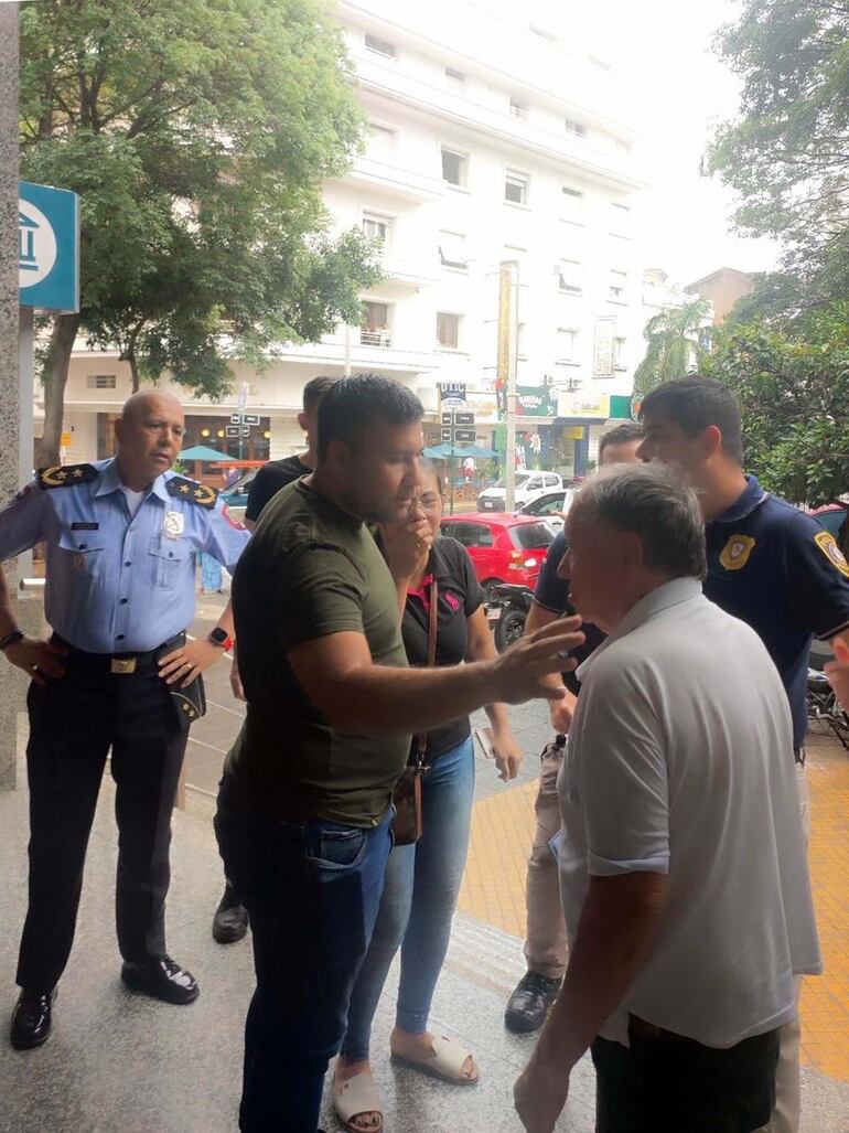 El cambista Gregorio Monges recibe el soporte de policías, tras el asalto en el microcentro de Asunción.