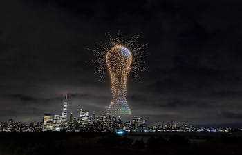 Gran trofeo iluminado en el cielo nocturno sobre un paisaje urbano lleno de edificios modernos.