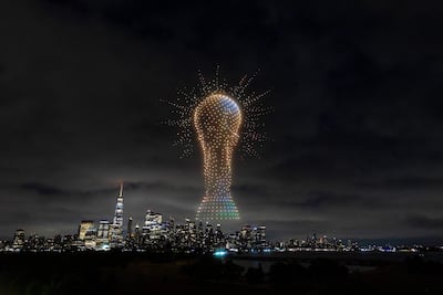 Gran trofeo iluminado en el cielo nocturno sobre un paisaje urbano lleno de edificios modernos.