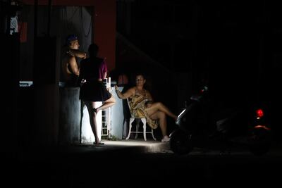 Personas hablan afuera de una casa durante un corte eléctrico, en La Habana (Cuba). 