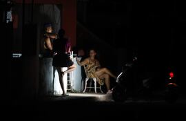 Personas hablan afuera de una casa durante un corte eléctrico, en La Habana (Cuba).