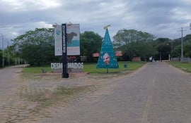 Cartel grande con 'Desmochados' y un árbol de Navidad decorado en un entorno urbano y tranquilo.