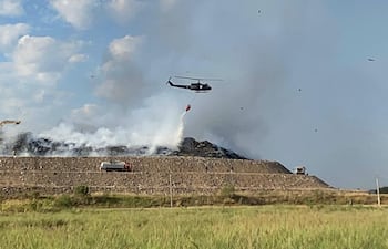 Militares sofocan incendio en vertedero de Remansito con helicóptero bambi.