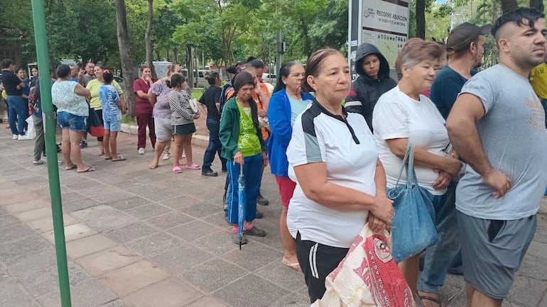 Personas forman fila para retirar los alimentos donados por mujeres del campo en el Día de la Mujer Paraguaya
