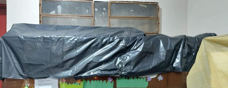 Elementos cubiertos por plástico negro en un ambiente cerrado de la Escuela Nacional de Comercio N° 2.
