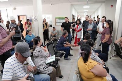 Isaías Ricardo Fretes y otros en la Unidad Sanitaria, con atmósfera de espera y diálogo entre médicos y pacientes.