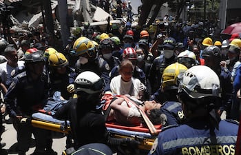Bomberos rescatan a una persona de un edificio derrumbado en Cali, Colombia.