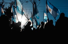 Personas sostienen banderas de Argentina.
