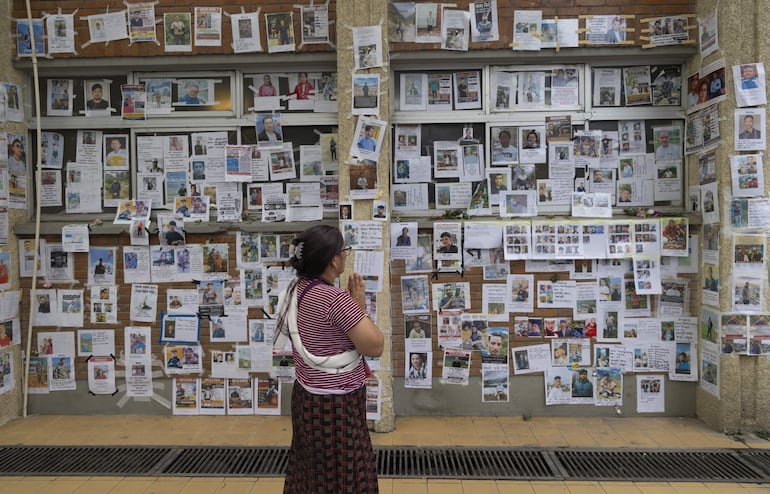 Una persona frente a fotografías de personas desaparecidas tras las inundaciones repentinas en el Hospital Universitario de Enseñanza de Tribhuvan (TUTH) en Katmandú, Nepal.