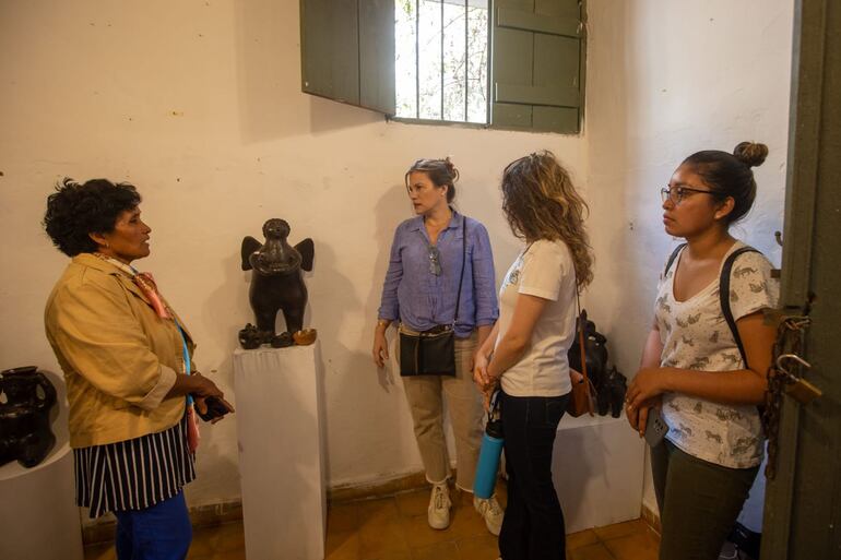 Personas admirando una obra de arte en cerámica moldeada a mano