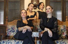 Susy Panizza, Lidia López, Dai Acosta y China Padrón Rossi posan con elegancia en un sofá clásico, vestidas con atuendos sofisticados.