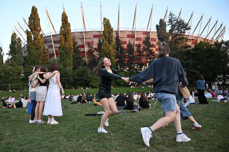 Fans bailando fuera del estadio nacional polaco en el Eras Tour de Varsovia el 3 de agosto de 2024.