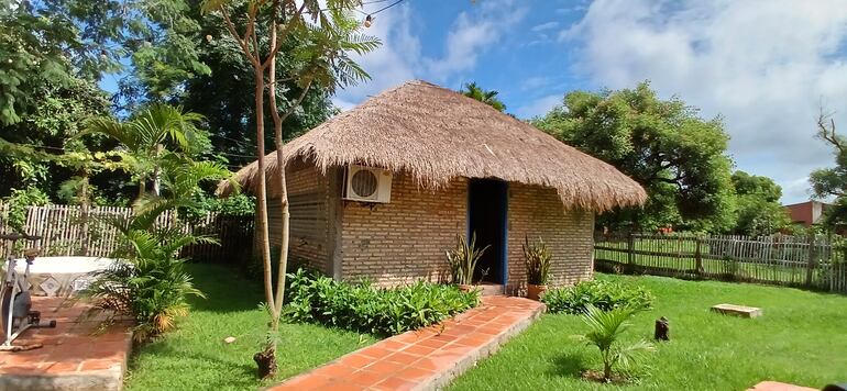 Cabaña con techo de paja rodeado de verde
