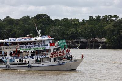 Una embarcación con integrantes de diversos movimientos sociales e indígenas navega por la bahía de Guajará este miércoles, en Belém (Brasil). Las embarcaciones llevan mensajes de protesta contra la Cumbre del Clima COP30 celebrada en Brasil.
