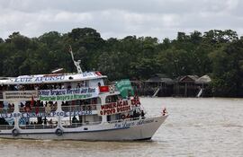 Una embarcación con integrantes de diversos movimientos sociales e indígenas navega por la bahía de Guajará este miércoles, en Belém (Brasil). Las embarcaciones llevan mensajes de protesta contra la Cumbre del Clima COP30 celebrada en Brasil.