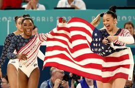 Simone Biles celebra con su equipo que vale oro.