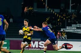 El yacaré Ramiro Amarilla intenta frenar sin éxito el avance charrúa.