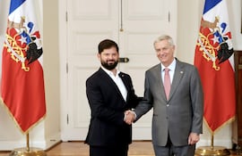 El presidente saliente de Chile, Gabriel Boric (i) saluda al mandatario electo José Antonio Kast.