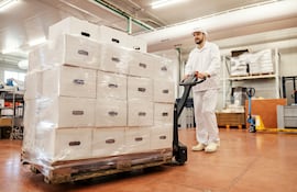 Trabajador de una industria cárnica transporta cajas con carne para exportación