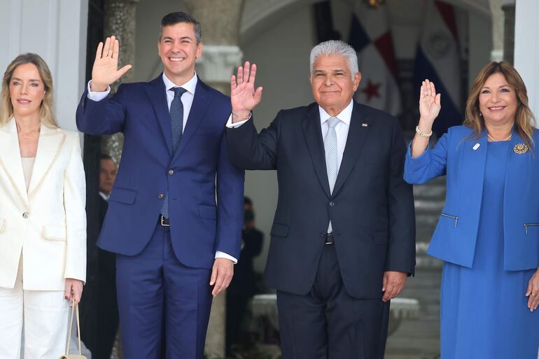 El presidente de Paraguay, Santiago Peña (c-i), y la primera dama de Paraguay, Leticia Ocampos (i), saludan junto al presidente de Panamá, José Raúl Mulino (c-d), y la primera dama de Panamá, Maricel Cohen de Mulino, a su llegada al palacio presidencial este lunes, en Ciudad Panamá (Panamá).