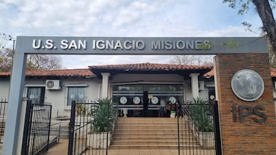 Entrada al Instituto de Previsión Social en San Ignacio, con un ambiente tranquilo y plantas ornamentales en la fachada.