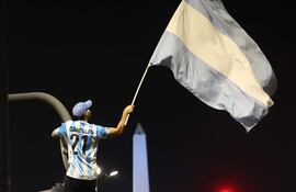 Un aficionado en Buenos Aires agita una bandera para celebrar el triunfo de Argentina frente a Inglaterra en la semifinal del Mundial.