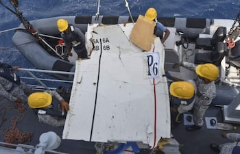 Rescatistas recuperan del mar piezas del avión de carga desaparecido.