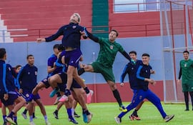 Silvio Beto Ovelar en entrenamiento, portero con camiseta verde, junto a futbolistas en tonos azul y gris, en ambiente dinámico.