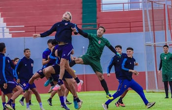 Silvio Beto Ovelar en entrenamiento, portero con camiseta verde, junto a futbolistas en tonos azul y gris, en ambiente dinámico.