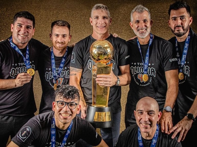 El cuerpo técnico de Martín Palermo en Olimpia celebrando con el trofeo de campeón del torneo Clausura 2024 del fútbol paraguayo.