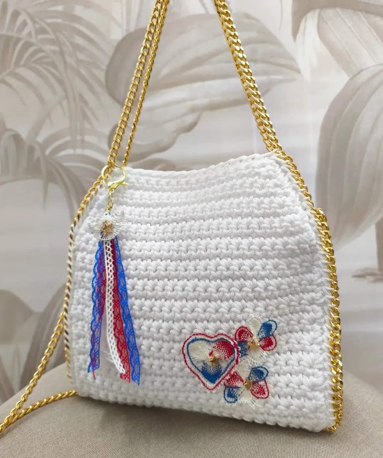 Bolso de crochet con bordados en colores patrios presentado en un entorno de diseño.