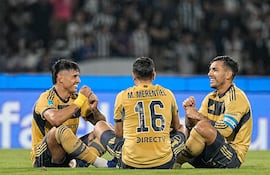 El delantero paraguayo, Adam Bareiro celebra su tanto simulando un juego de caras con el atacante Miguel Ángel Merentiel y el capitán Leandro Paredes